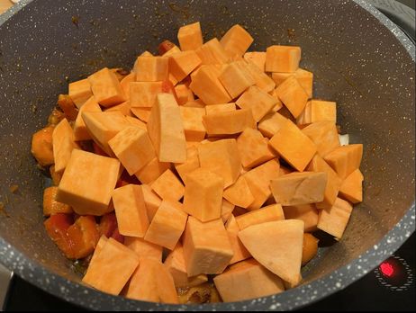 Rezept für eine Süßkartoffel-Kokos-Suppe: Brate die Paprika, Möhren und den Kürbis eine Minute an.
