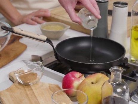 Pfannen-Granola mit Joghurt und Apfel: Erhitze nun das Kokosöl gemeinsam mit dem Ahornsirup in einer beschichteten Pfanne. 