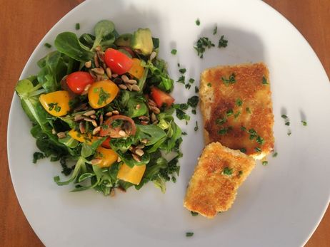 Rezept für ein paniertes Feta-Schnitzel mit Salat: Zuletzt alle Zutaten anrichten und genießen.