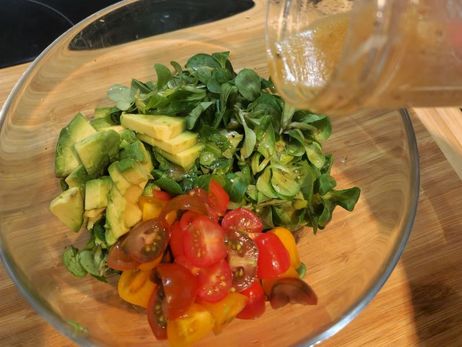 Rezept für ein paniertes Feta-Schnitzel mit Salat: Vermenge nun das Dressing mit dem Salat sowie dem Dill und der Petersilie.