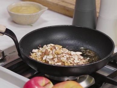 Pfannen-Granola mit Joghurt und Apfel: Röste Flocken-Nuss-Mischung ca. 5-7 Minuten bei mittlerer Hitze in der Pfanne an.