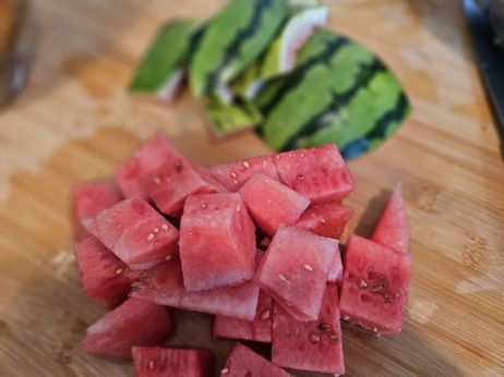 Melonen-Erdbeer-Smoothie: Halbiere die Wassermelone, schneide Hälfte in dicke Scheiben und entferne die Schale. Teile das Fruchtfleisch anschließend in grobe Würfel.