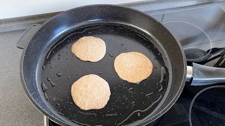Rezept für Bananen-Hirse-Pancakes: Jetzt kannst du den Teig als kleine Kreise in die Pfanne geben.